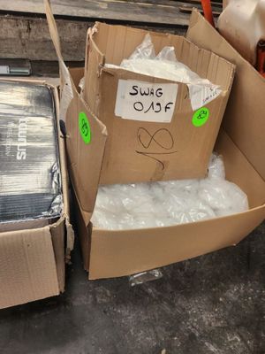 deux cartons contenant des articles emballés dans du plastique, dans un entrepôt