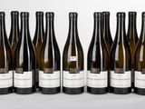 six bottles of wine are lined up in a row on a table