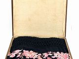 an open suitcase with a black and pink floral design