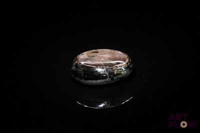 une photo d'une bague posée sur une surface noire