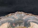 a silver plate with a clock on it on a black surface