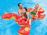 Deux personnes et un enfant sont assis sur un crabe gonflable dans une piscine