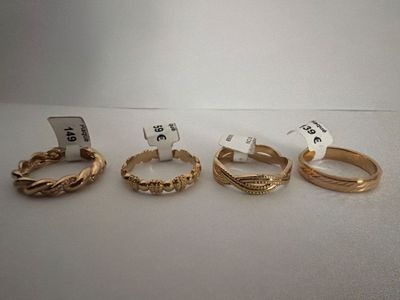 five gold rings with names on them sitting on a table