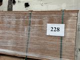 une grande pile de panneaux de contreplaqué dans un entrepôt, sur laquelle est apposée une étiquette de prix