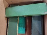 a cardboard box with several different colored books inside of it