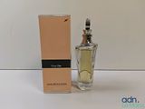 le flacon de parfum se trouve à côté de la boîte, sur la table