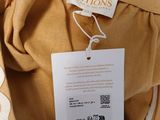 the back of a tan jacket with a white label on it