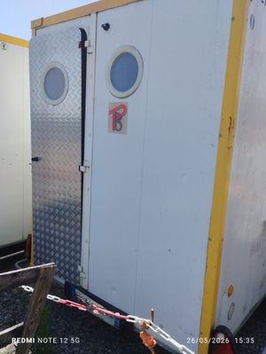 deux toilettes portables blanches et jaunes installées sur un terrain