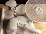 une table sur laquelle se trouvent un ventilateur, un ventilateur et d'autres objets