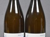 two bottles of wine sitting next to each other on a table