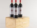 three bottles of red wine are sitting on a wooden box