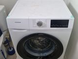 une machine à laver et des toilettes dans une petite pièce