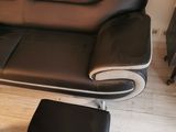 a black leather couch and ottoman in a living room