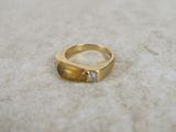 a gold ring with a diamond on it sitting on a table