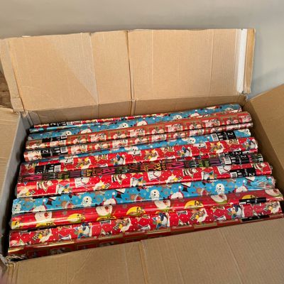 une boîte en carton remplie de papier cadeau aux motifs variés