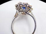a close up of a diamond ring on a white surface