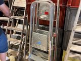 un homme qui se tient à côté d'un escabeau