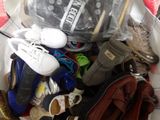 de nombreuses paires de chaussures dans un sac en plastique posé par terre