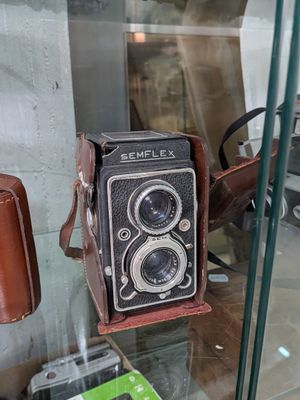 une vitrine sur laquelle sont posés un appareil photo et un téléphone portable