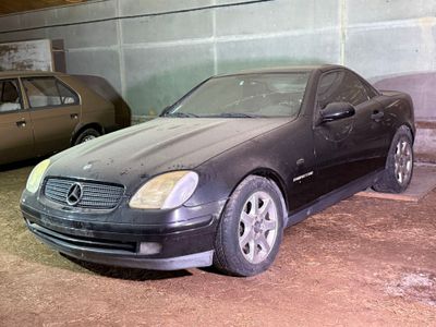 une voiture noire garée sur un parking à côté d'une voiture marron