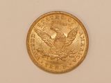 a close up of a gold coin on a white surface