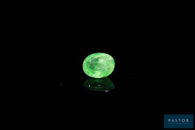 a close up of a glowing green stone on a black surface