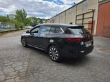a black car parked in a parking lot next to a building