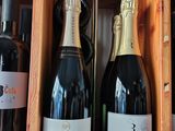 several bottles of wine are in a wooden box on a shelf