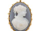 un gros plan du visage d'une femme sur un pendentif plaqué or