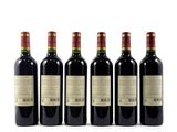 four bottles of wine are lined up on a white surface