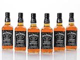 quatre bouteilles de whisky Jack Daniel's alignées les unes à côté des autres
