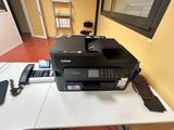 a printer sitting on top of a desk next to a phone