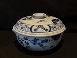 a blue and white bowl with a lid sitting on a table
