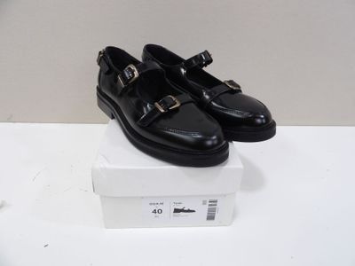 a pair of black shoes sitting on top of a box