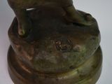 a bronze statue of a cat sitting on top of a bowl