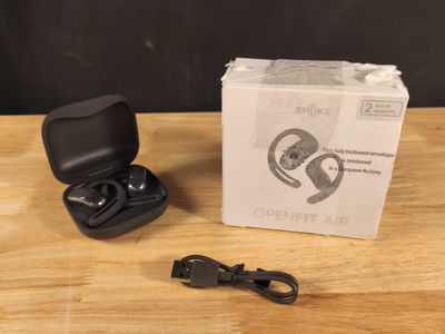 an open box with a pair of earphones sitting on top of a wooden table