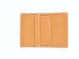 un gros plan d'un portefeuille en cuir beige sur fond blanc
