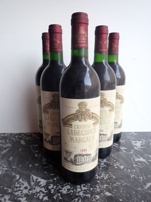 six bouteilles de vin rouge sont alignées sur une table