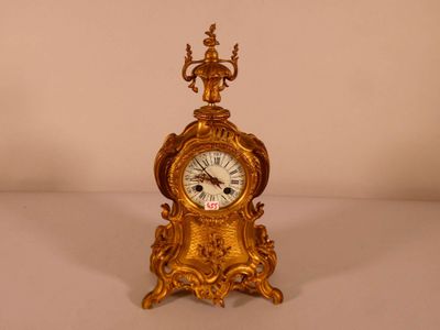 une horloge en or posée sur une table blanche