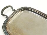 a silver tray with a handle on a white surface