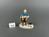 the figurine of a man with a dog is posed next to a number 11