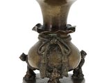 un vase en bronze posé sur un socle