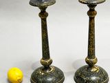 pair of black and gold candlesticks with a lemon next to them
