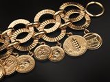 a close up of a bunch of gold coins on a black surface
