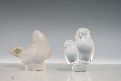 deux figurines d'oiseaux posées l'une à côté de l'autre sur une table