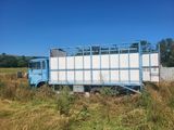 un gros camion bleu garé dans l'herbe