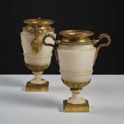 two vases that are sitting on a white table