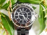 a close up of a watch on a table with flowers