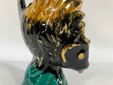 a black and gold statue of a dog on a green base