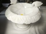 a white bowl with a bird on it on a table